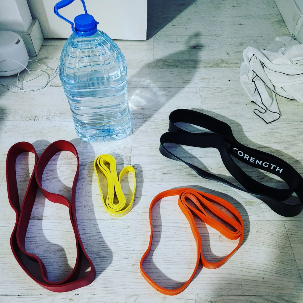 Simple home gym equipment: resistance bands and water bottles used for effective home workouts