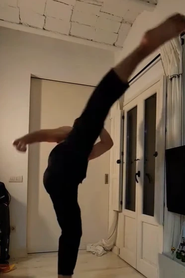 Practicing martial arts techniques at home without a partner, focusing on solo drills in an open space